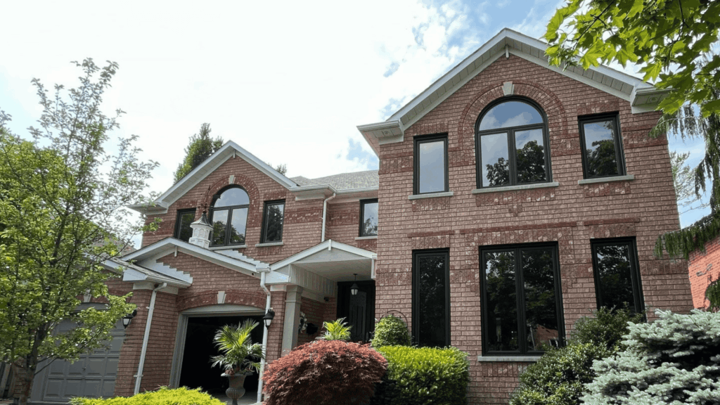 House showcasing Frank by Ostaco painted black frame replacement vinyl windows